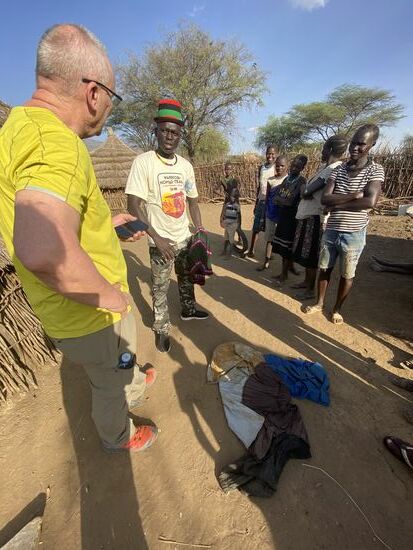 Dies ist Emma (Emanuell), unser heutiger lokaler Guide. Er ist ein junger und stolzer Karamajong, der alles über die Kultur zu wissen scheint. Nicht nur Thomas ist interessiert. Die Kinder der Familie lauschen gespannt.