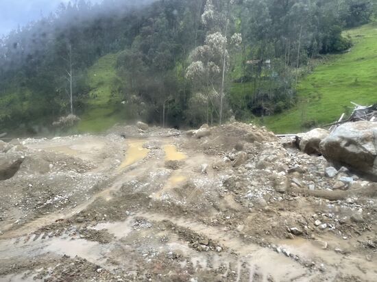 Hier wurde die Straße komplett verschüttet. Sie musste mit schwerem Gerät geräumt werden. Man sieht immer noch den Schlamm und die Steine.