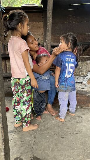 Weil es immer noch regnet, holen die Frauen Früchte, von denen sie das Fruchtinnere als Farbe zum Bemalen der Haut nutzen