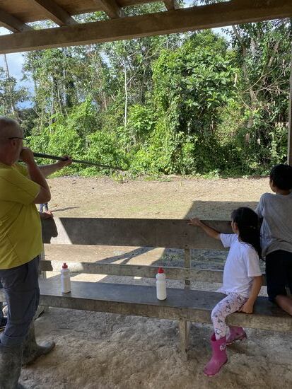 Dann holt Emard ein riesiges Blasrohr raus und zeigt uns wie sie es zur Jagd mit Pfeilen benutzen—wir sollen auch probieren