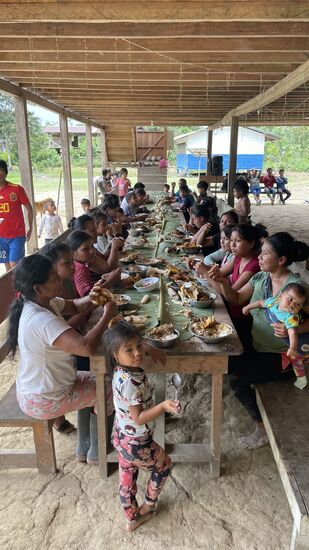 Alle setzen sich und hauen rein! Es gibt Schweinefleisch—Ein paar Männer haben einige Schweine erlegt