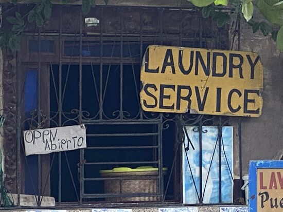 Es dauert, bis die Dame den Schlüssel hervorgekramt hat und dann das rostige Schloß mühsam öffnet