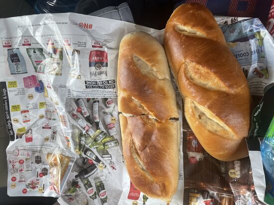 Wir stoppen noch an einem Kiosk und holen uns 2 Brötchen und eiskalte Cola—die Brötchen schmecken wir unsere Campingbrötchen. Und dass sie in Zeitungspapier eingewickelt sind, wie bei uns ganz früher-