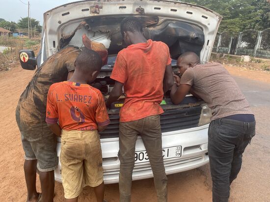 Ich glaube, sie wechseln einen Keilriemen—da braucht man kleine Hände für die engen Zwischenräume