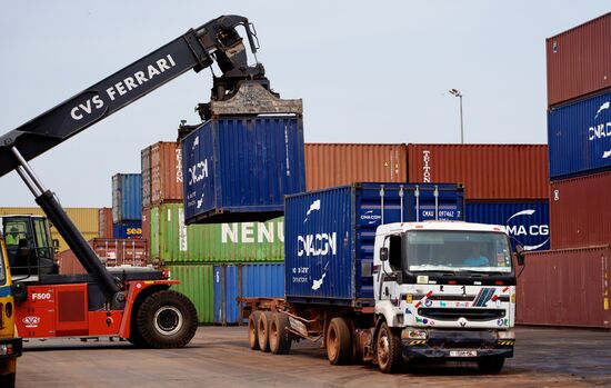 LKW werden entladen und die Container für die Verschiffung zwischengelagert.
