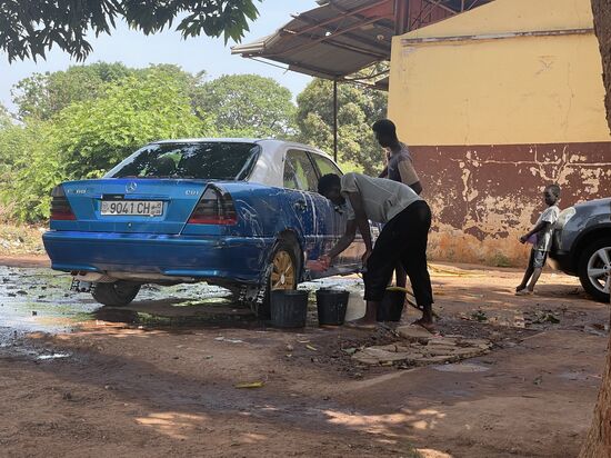 …. bringt der Fahrer das Auto zum Waschen. Er und Lamin haben Hunger. Sie bestellen sich Reis mit Fisch. Wir haben vorhin ein paar  Bananen gekauft und essen diese jetzt