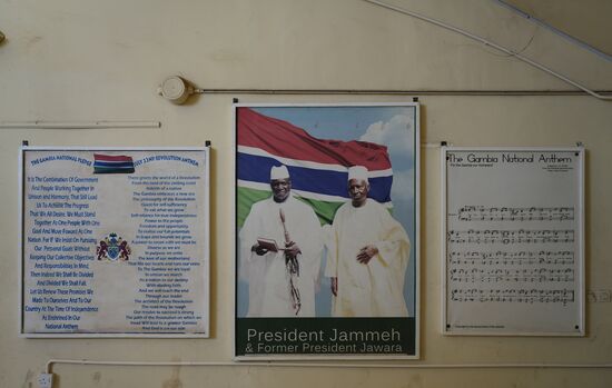 Zum Gedenken an den Präsidenten Jammeh und rechts die Nationalhymne.
Jammeh war in 1994 als Leutnant der Militärpolizei einer der Kräfte hinter dem Militärputsch und bis 1996 führte er die Militärjunta an. In 1996 wurde er nach den 1. Parlamentswahlen Staatspräsident. 10 Jahre führte er das Land in Richtung Modernisierung und forcierte auch den Tourismus. Nach 10 Jahren folgte dann aber die Zeit der Diktatur, die von Folter, Morden und Unterdrückung gekennzeichnet war. Gambia hat sich mehr und mehr der restlichen Welt abgewendet. Opposition wurde niedergemacht und er führte auch die Todesstrafe wieder ein. In 2015 rief er in Gambia die Islamische Republik aus. Bereits in 2011 zweifelt man die Wahlergebnisse an. Doch niemand konnte den Wahlbetrug tatsächlich nachweisen. In 2016 wurde er dann abgewählt. Monatelang hat Jammeh das Wahlergebnis abgestritten und sich geweigert, den Präsidentenpalast zu verlassen. Sein Nachfolger (Adama Barrow) wurde in der gambischen Botschaft im Senegal vereidigt und von den Völkern der Welt als neuer Präsident anerkennt. Interventionen aus anderen westafrikanischen Ländern, Jammeh möge den Stuhl freimachen, kam der Diktator nicht nach. Die Situation spitzte sich zu und eine Koalition verschiedener westafrikanischer Armeen marschierte auf und rückte bis zur gambischen Grenze vor. Die UN forderte Jammeh auf zurückzutreten. Man wollte einen Krieg vermeiden. Erste Einheiten rückten dann Richtung Banjul und letztendlich war der abgewählte Präsident bereit, ins Exil zu gehen. Er bat sich einige Tage für die Abreise aus und in diesen Tagen raffte er ca. 25 Millionen USD an Vermögen aus der Staatskasse und flog damit mit seinem Clan ins Exil. Seine brutalen Schlägertruppen verschlug es teilweise nach Senegal und nach Guinea Bissau, wo sie heute noch ihr Unwesen treiben.