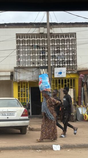 Frauen, die ihre schweren Einkäufe auf dem Kopf nach Hause tragen