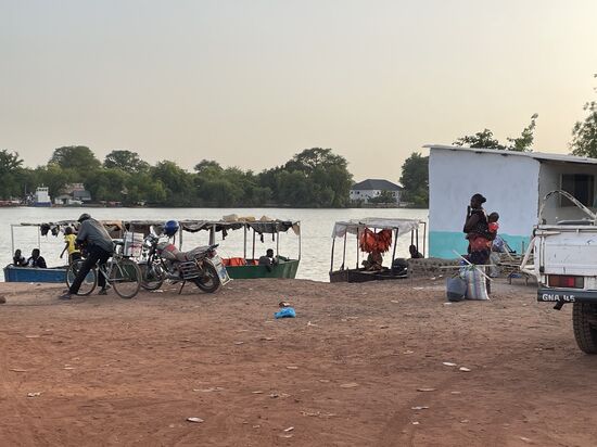 Eine Mutter mit Baby auf dem Rücken wartet…