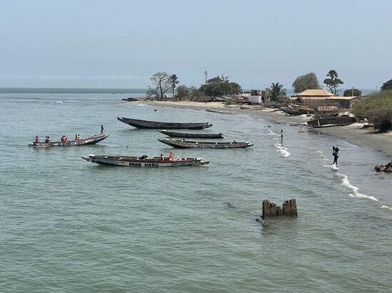 Man kann sich auch einen Platz auf einem dieser Boote kaufen, wenn es schneller gehen soll. Wir beobachten, wie die Passagiere durch das Wasser zu den Booten getragen werden 