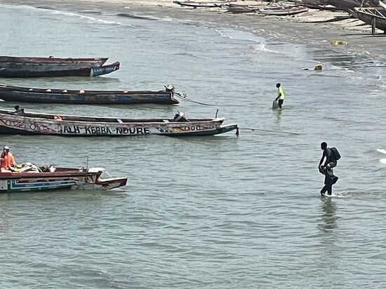Mit Gepäck kommt der Junge trockenen Fußes ins Boot 
Der Preis für die große Fähre beläuft sich auf 30 GMD-für einen Platz auf dem kleinen Boot zahlt man etwa 600 GMD