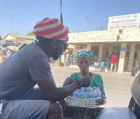 Schnell kauft Dawda noch ein paar kühle Getränke von der Dame