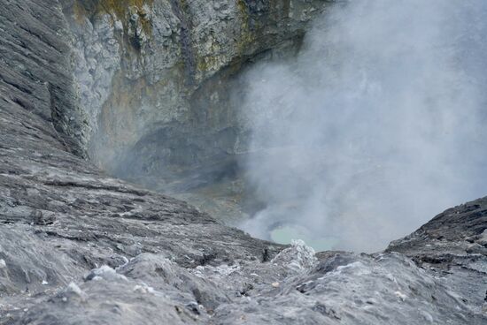 Der Wind weht den Dampf weg und der kleine Kratersee kommt zum Vorschein