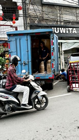 Auch er lacht und winkt uns zu