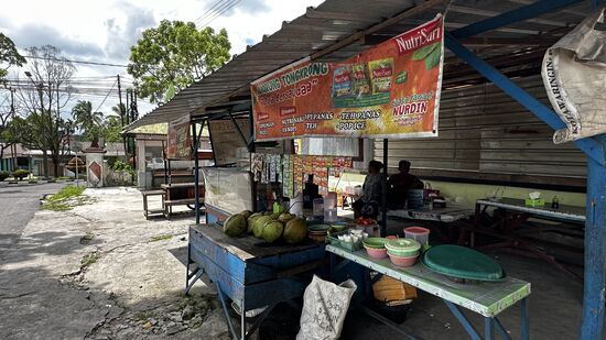 Hier sitzen schon einige Männer. Sie trinken Eistee und essen auch. Da hier keiner Englisch spricht, habe ich mir angewöhnt, einfach auf die Sache zu zeigen, die ich möchte—so auch hier auf den Eistee der Männer
