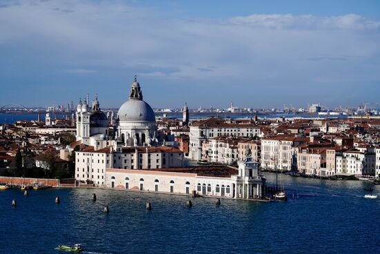 Fuer 8 Euro p.P. gehts mit dem Fahrstuhl hoch auf den Turm. Man hat von hier einen tollen Blick auf Venedig und auch auf die anderen Inseln der Lagune. Diese Insel ist mit 490 x 320 Metern nicht sehr groß. Neben der Basilika gibt es ein Kloster mit einem Labyrinth-Garten und ein paar Häuser. In 2001 gab es hier nur  11 Einwohner- heute, 2023 werden es kaum mehr sein. 
Oben vom Turm wie gesagt eine tolle Aussicht auf Venedig. Sehr gut zu sehen die Basilika di Santa Maria della Salute.