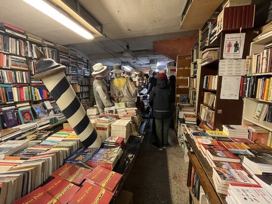 Ein Bücherladen? Ich googele mal: Tatsächlich handelt es sich hier um den Buchladen "Libreria Acqua Alta" auf deutsch: "Buchladen Hochwasser"
Im Mittelpunkt des Ladens befindet sich eine alte Gondel--vollgestopft mit Büchern