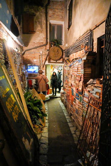 Ein schmaler Gang-rechts und links sind durchnässte, aufgeweichte Bücherstapel