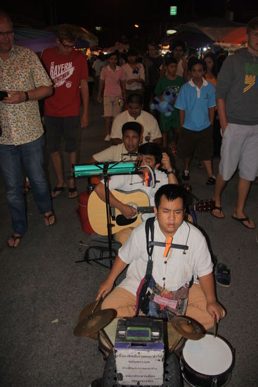 Behinderte Strassenmusiker in der Mitte der Strasse machen unterhaltsame Musik.