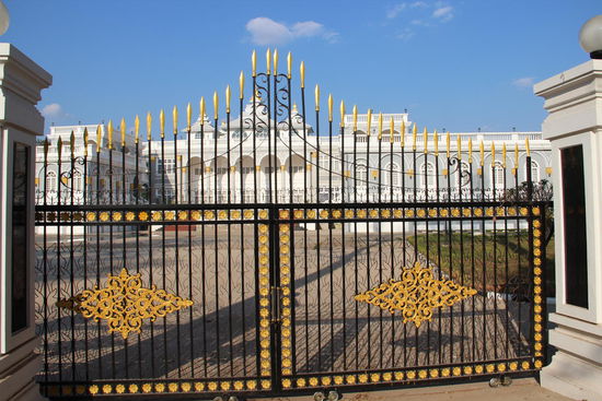ein prächtiges Parlamentsgebäude hinter schweren Eisentoren....