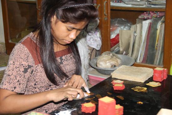 winzige Goldblättchen werden von geschickten Händen verpackt...