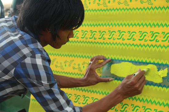 Baumwollstoffe werden gespannt und mit Schablonen in verschiedenen Schritten und Farben bemalt