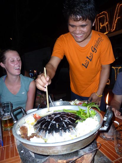 Wir gehen mit einem holländische Pärchen laotisches "Fondue" essen. In der Mitte des Tisches befindet sich ein Loch mit einem Kübel mit heißen Kohlen, auf dem ein Topf platziert wird und dünne Scheibchen Fleisch werden auf der Wölbung gebraten. Das Gemüse wird in der Senke drum herum gekocht, eine vorzügliche Brühe, die anschließend geschlürft wird.