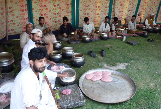 Die Männer sind für die Zubereitung der Hackklopse zuständig. Das Fleisch wird lebendig geliefert und traditionell verarbeitet und mit einem Holzhammer zu Brei geklopft. Die Frauen bereiten das Gemüse vor.